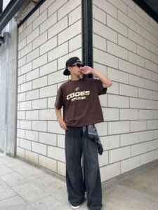 Casual college outfit with a dark oversized graphic t-shirt and loose-fit blue denim jeans